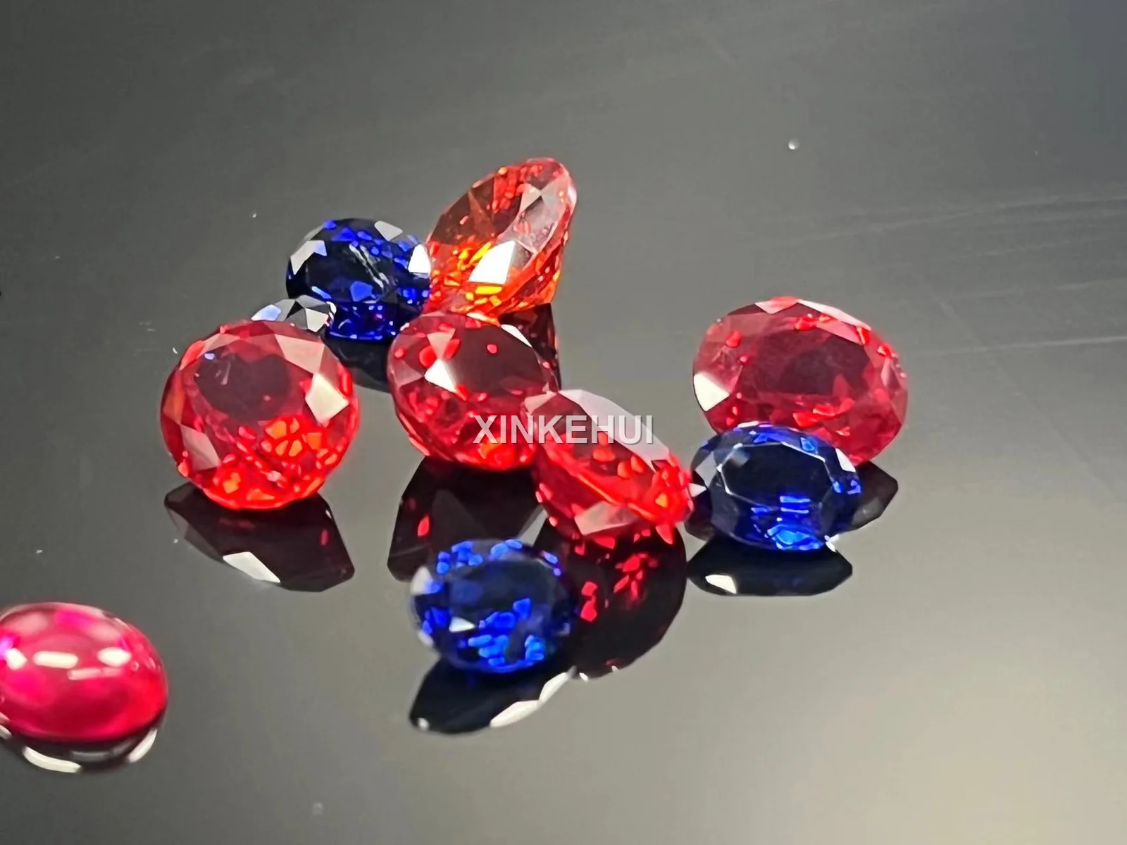 Red, blue and yellow colored sapphire gemstones on a dark surface